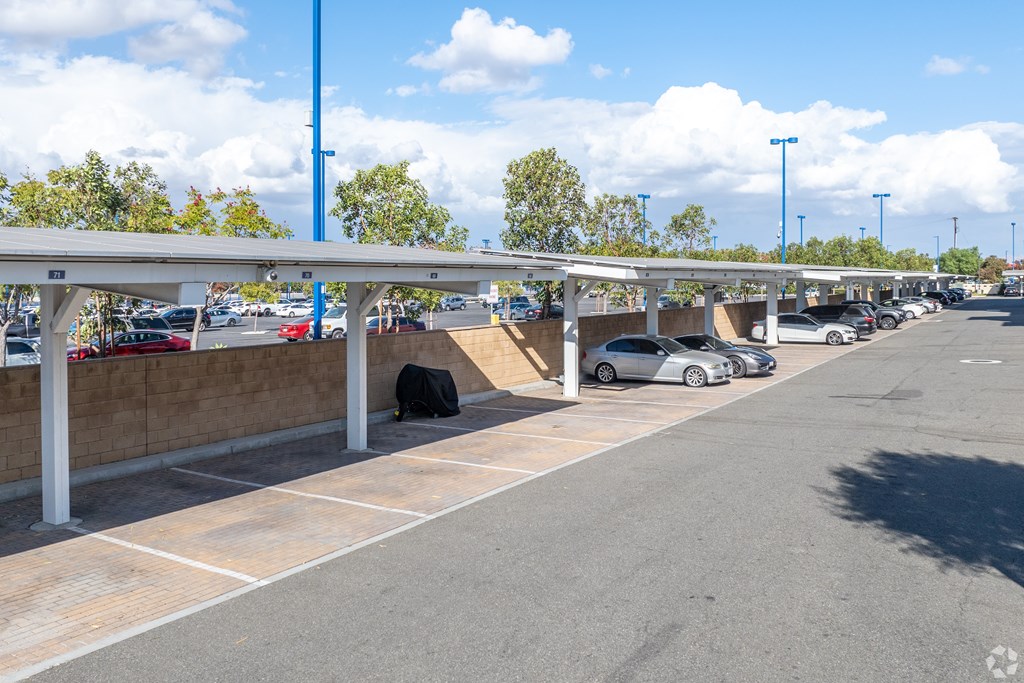A parking lot with cars parked under a canopy.