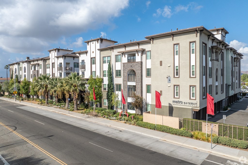 A row of modern townhouses with a street in front.