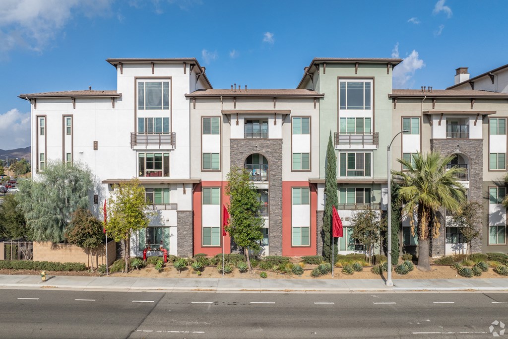 A row of modern townhouses with red, white, and green exteriors.