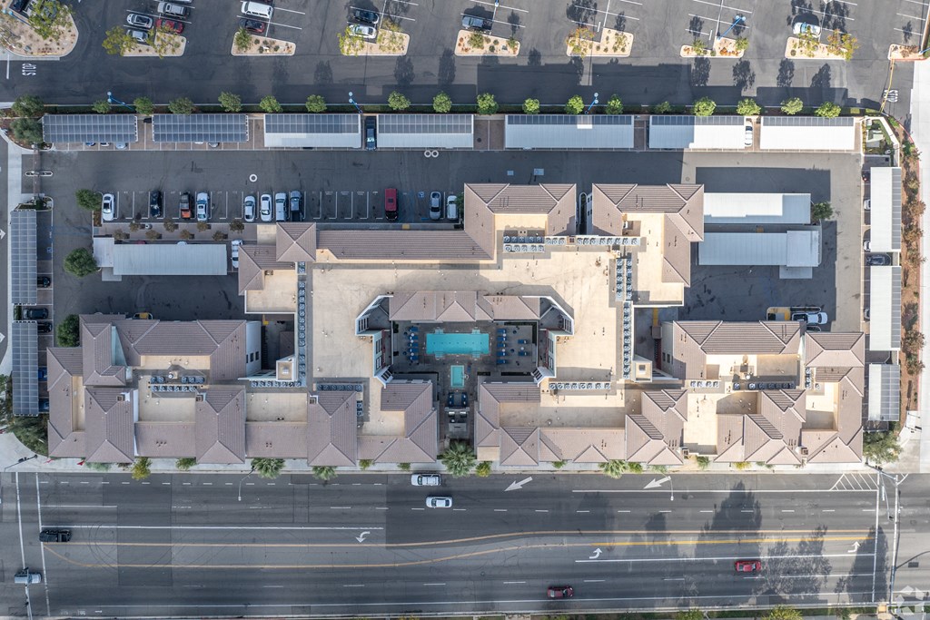 An aerial view of a parking lot and a building with a large entrance.