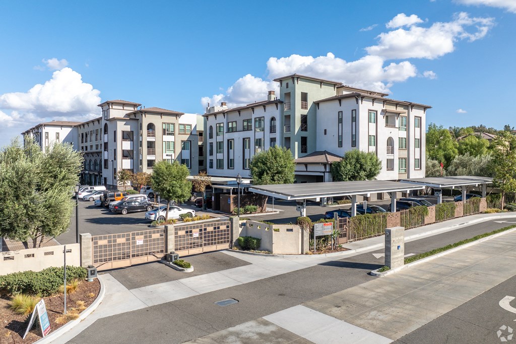 A large building complex with a parking lot in front.