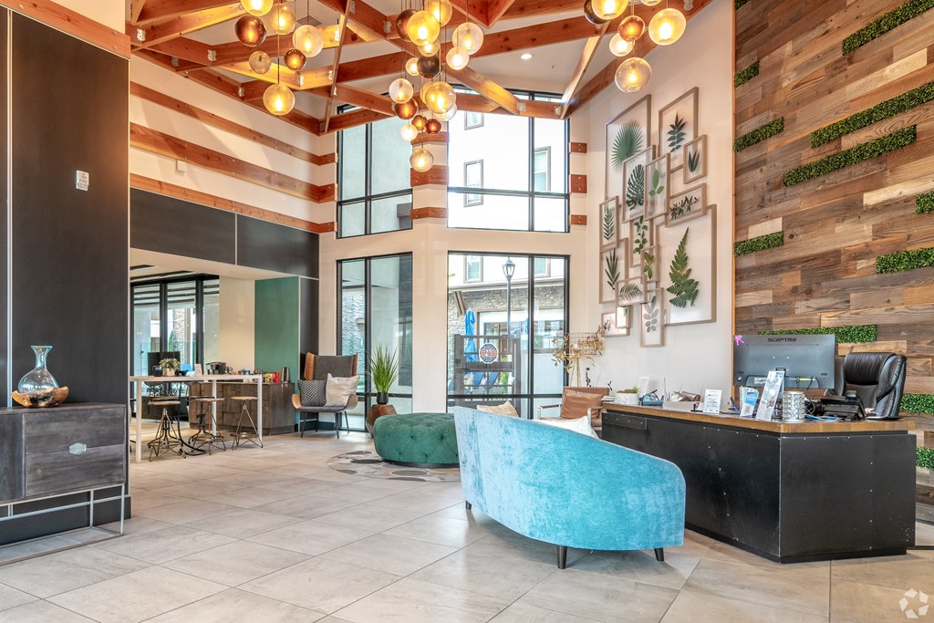 A reception area with a blue chair and a green ottoman.