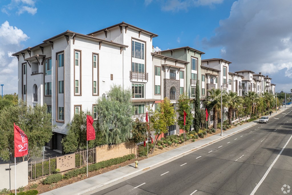 A row of modern townhouses with a street in front.