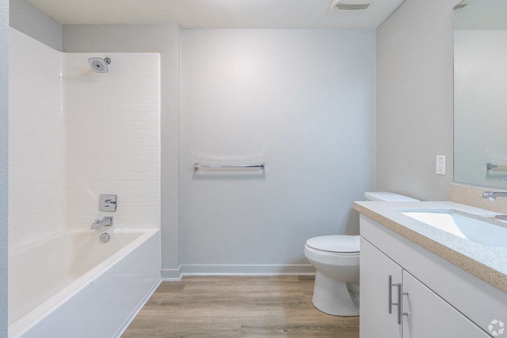 A white bathroom with a toilet, sink, and bathtub.