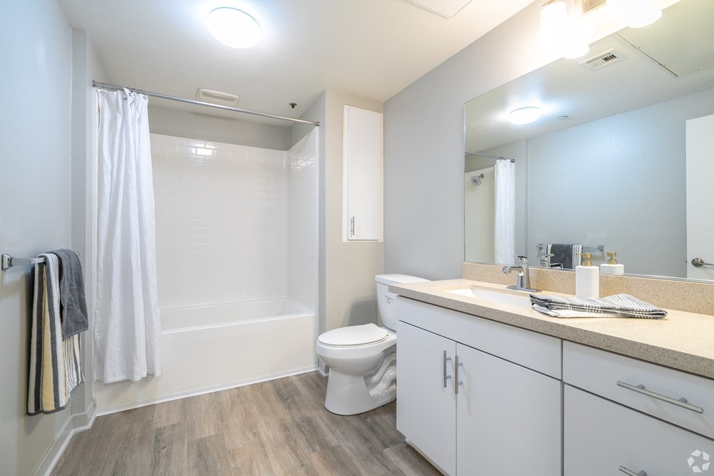A white bathroom with a toilet, sink, and shower.