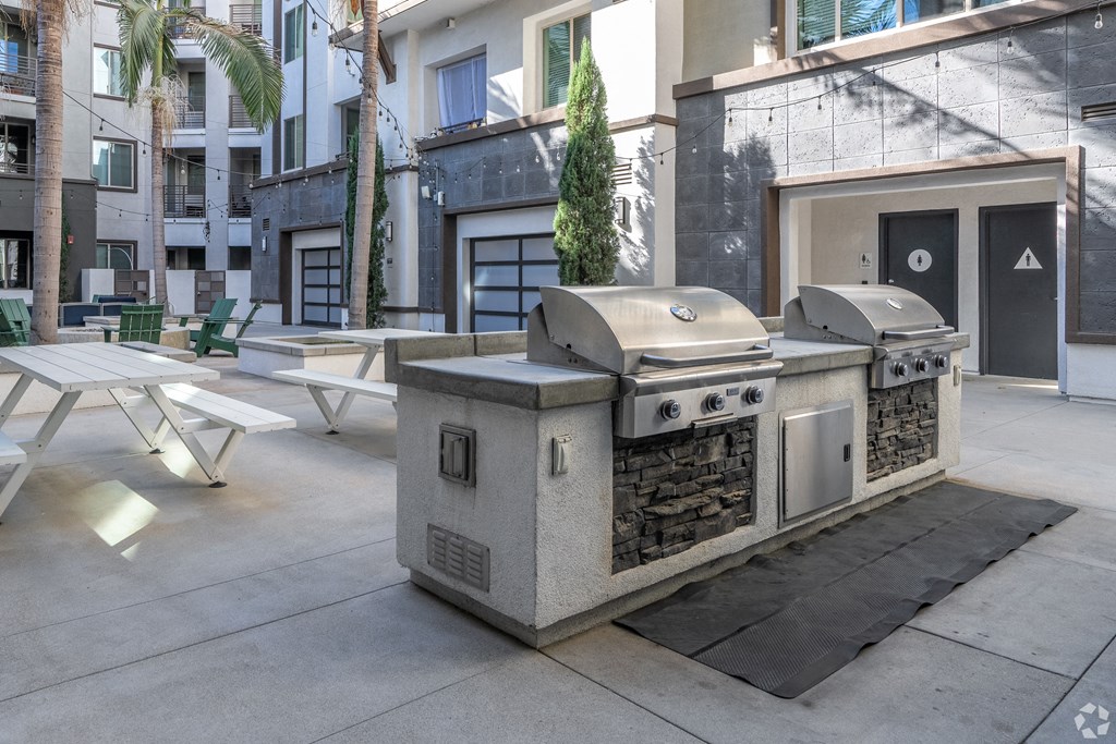 A modern outdoor kitchen with a grill and sink.