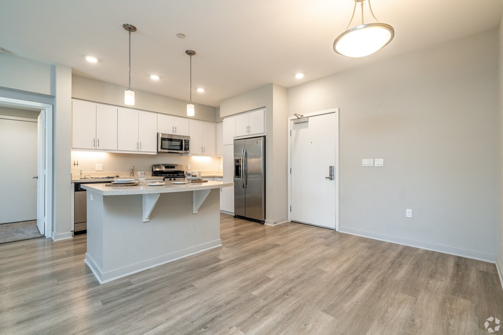 A kitchen with a white island and wooden floors.