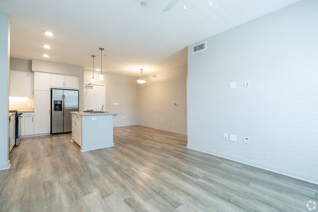 A kitchen with a refrigerator, sink, and cabinets is shown.