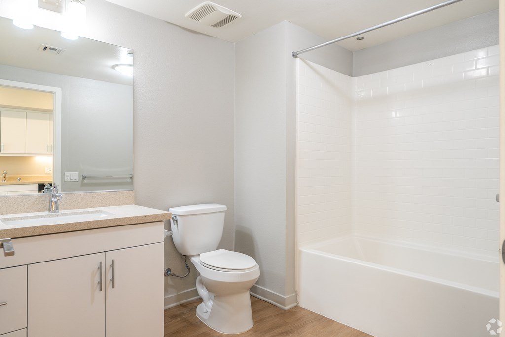A white bathroom with a toilet, sink, and bathtub.