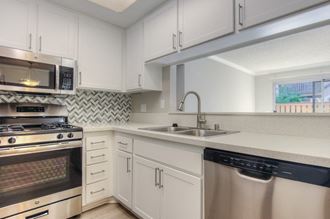 Renovated kitchen with white cabinets, countertops and stainless steel appliances