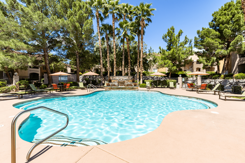 Spring Valley NV Apartments for Rent - Aviara - Outdoor swimming pool with clear water, lounge chairs, and additional seating with umbrella coverings