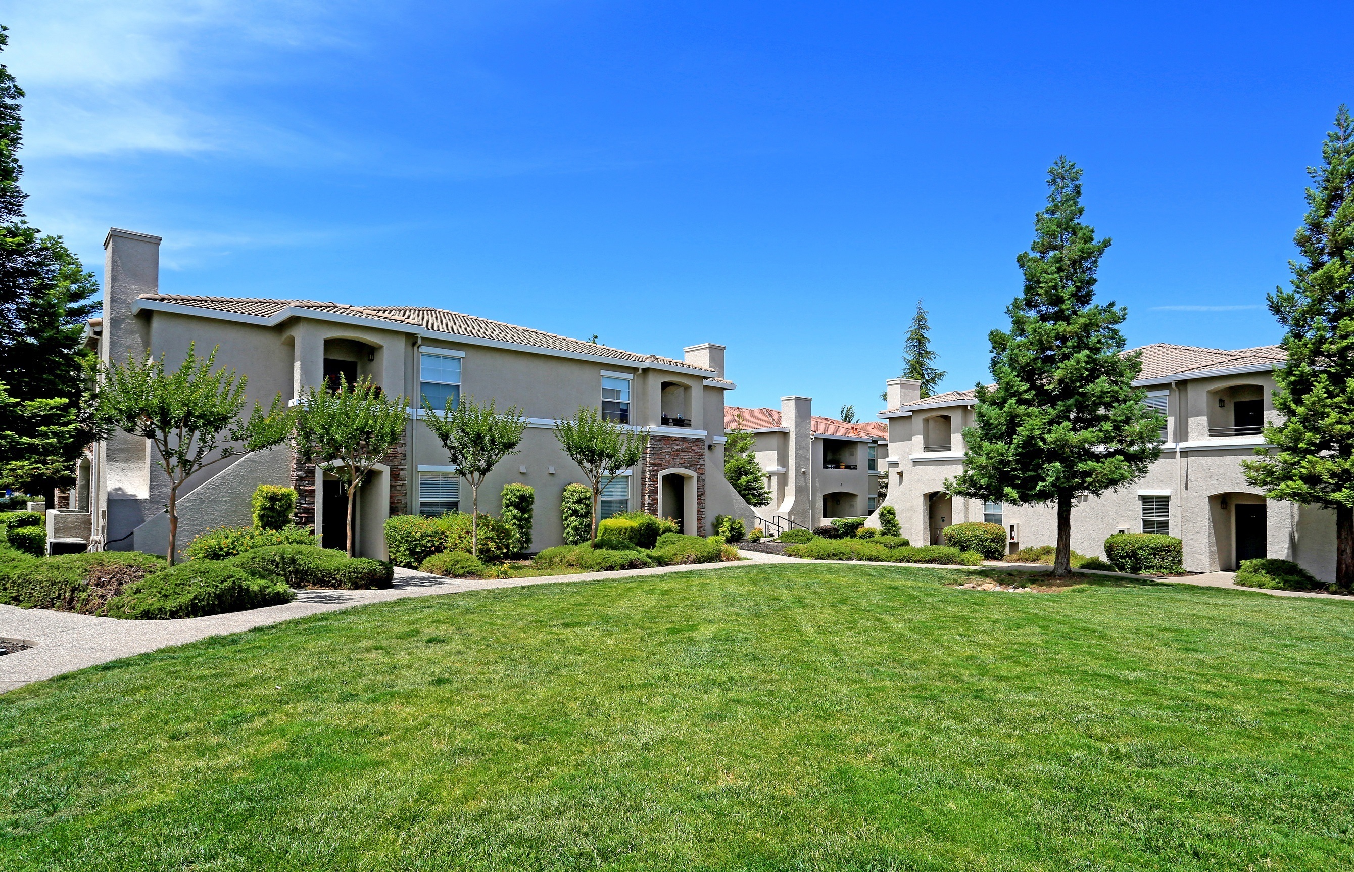 A row of houses with green lawns in front.