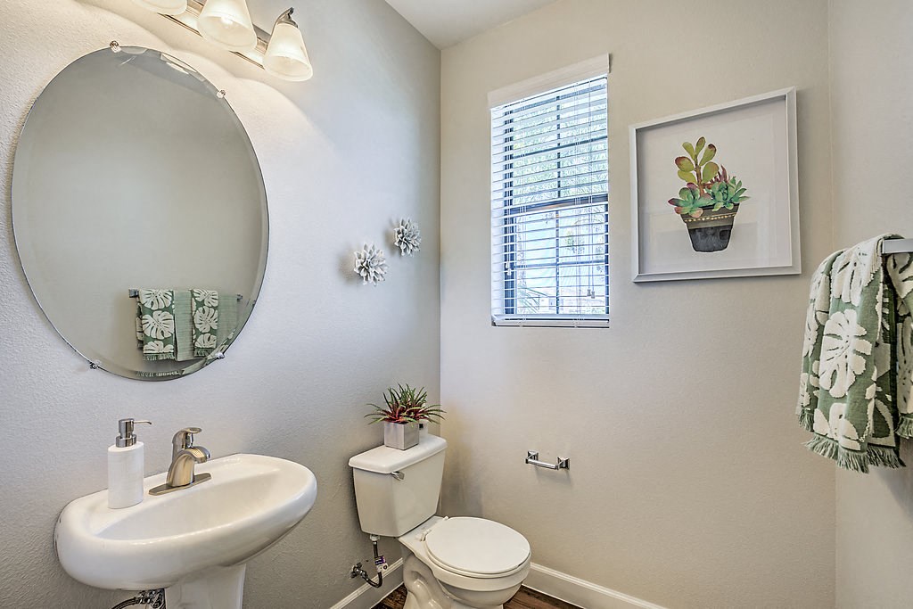 Refresh in style at The Michael B's updated guest bathroom, featuring a crisp white sink and toilet bathed in natural light.at The Michael B Townhomes and Flats, Las Vegas, NV