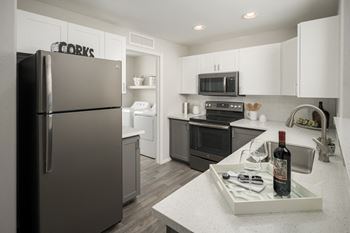 a kitchen with stainless steel appliances and white cabinets at Trevi Apartment Homes, Chandler, 85224