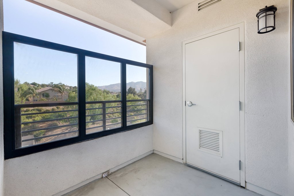 the living room has a large window and a door to the balcony at Metro Gateway, Riverside, CA