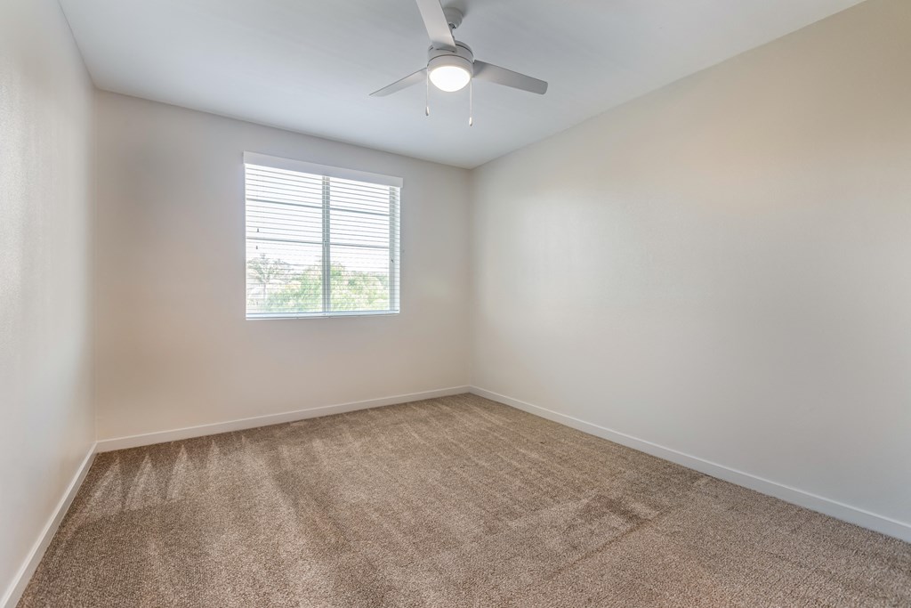 an empty room with a ceiling fan and a window at Metro Gateway, Riverside, CA
