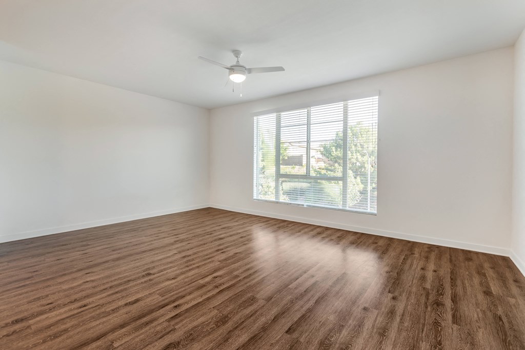 an empty living room with a window and wood flooring at Metro Gateway, Riverside, 92503