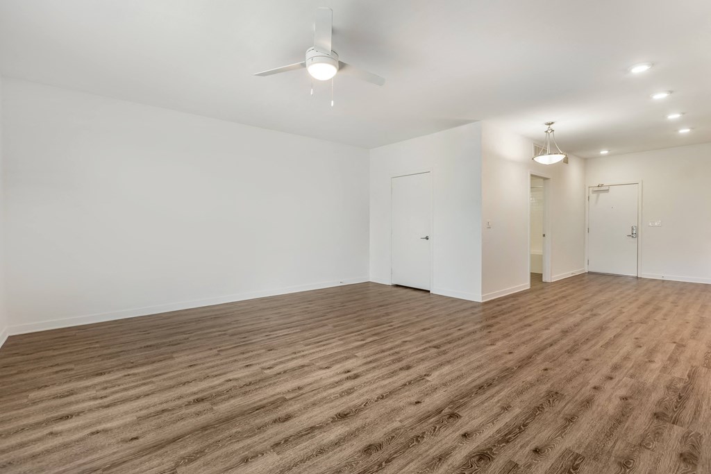 a living room with white walls and wood flooring and a ceiling fan at Metro Gateway, Riverside, 92503