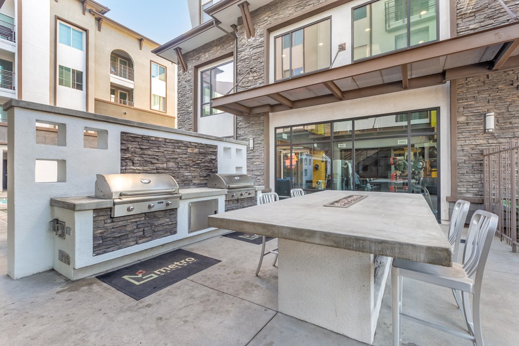 a patio with a table and a grill on the side of a building at Metro Gateway, Riverside, CA, 92503