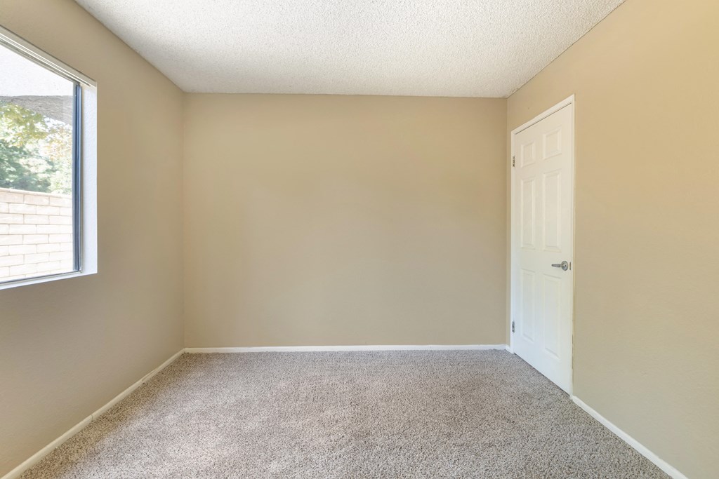 an empty room with a door and a window