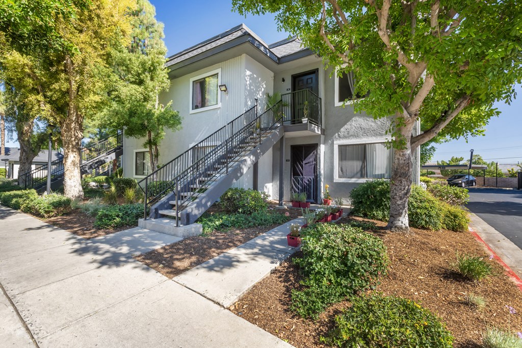 a house with stairs and trees in front of it