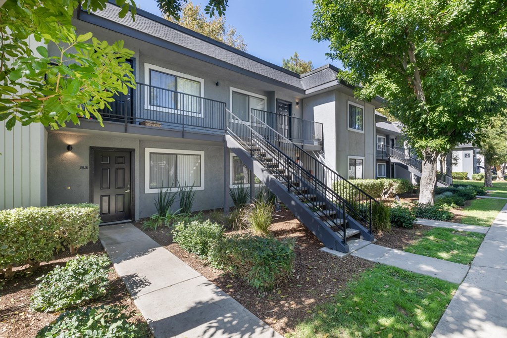 an apartment building with stairs and a sidewalk