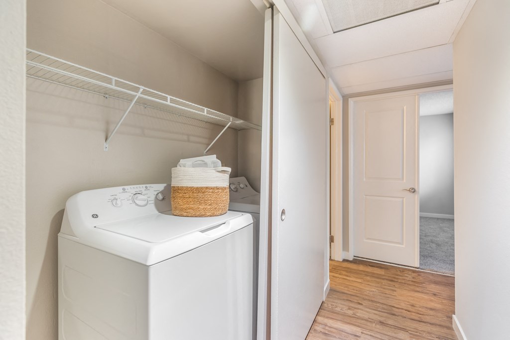 a washer and dryer in a laundry room with a door to a closet