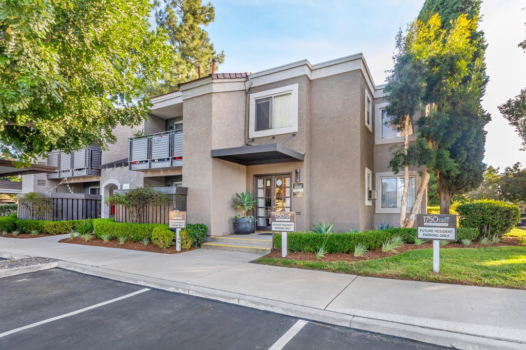 a building with a sidewalk and trees in front of it