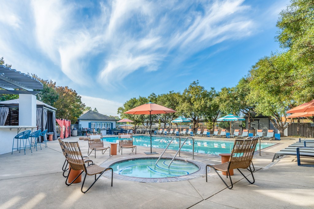 Our resort style jacuzzi and swimming pool is filled with lounge chairs and umbrellas. Perfect for summer!