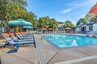 Our resort style swimming pool is filled with lounge chairs and umbrellas