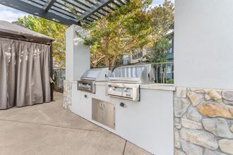 We offer two stainless steel barbecue grills on the side of a patio.