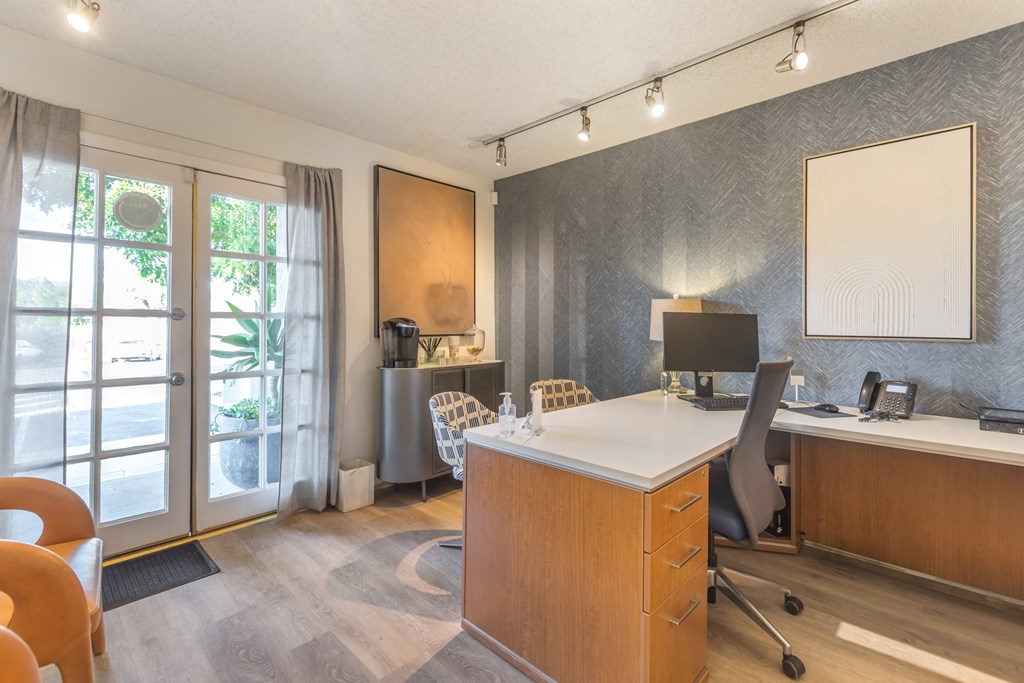 a home office with a desk and a sliding glass door