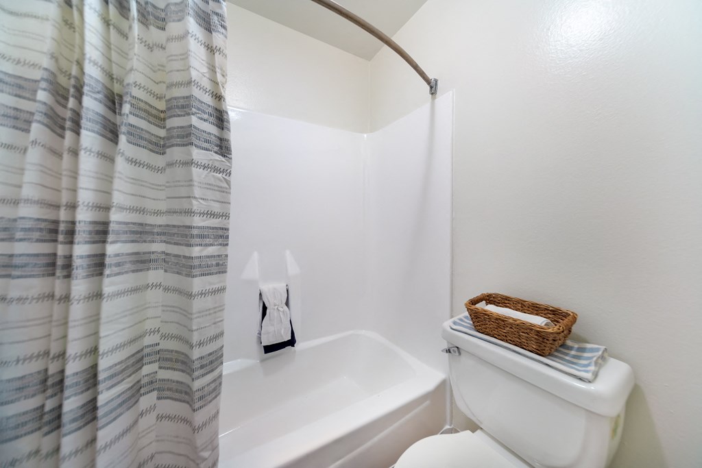 the bathroom has a shower curtain and a toilet and a sink