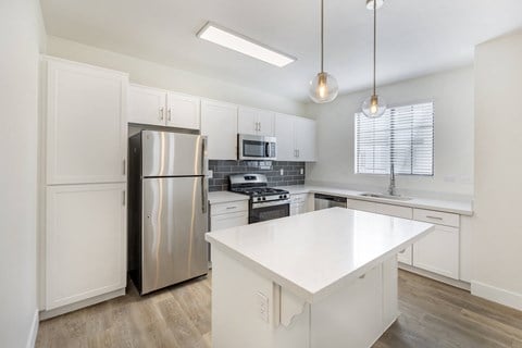 Experience the epitome of modern elegance at The Michael B apartments, where sleek white cabinetry meets state-of-the-art stainless steel appliances, setting the stage for gourmet culinary adventures.