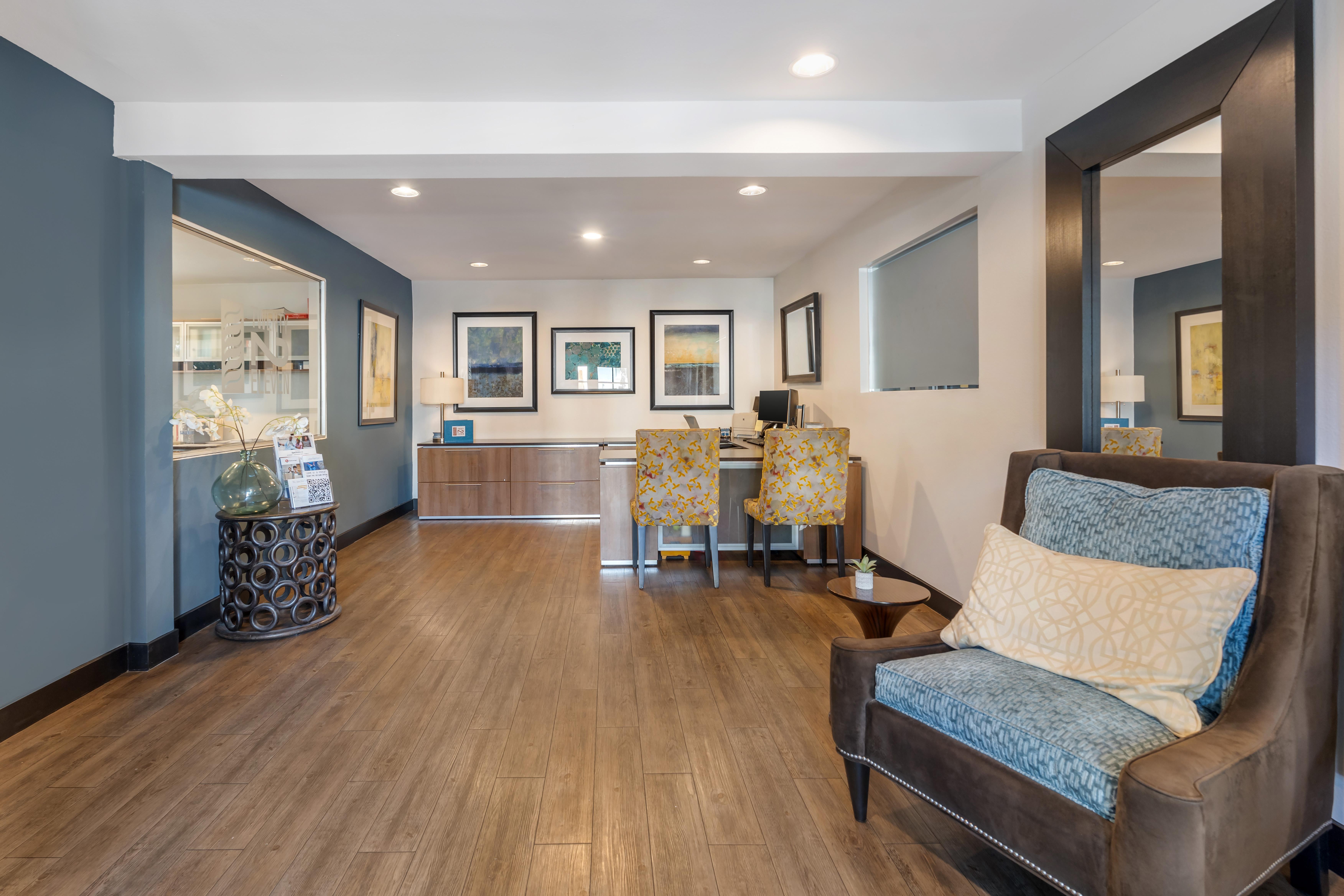 A living room with a brown couch and a wooden floor.