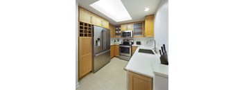 a modern kitchen with stainless steel appliances and wooden cabinets