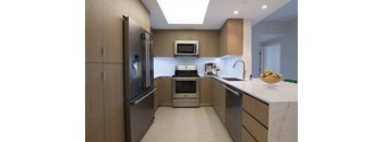 a modern kitchen with stainless steel appliances and wooden cabinets
