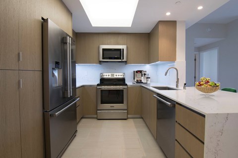 a modern kitchen with stainless steel appliances and wooden cabinets
