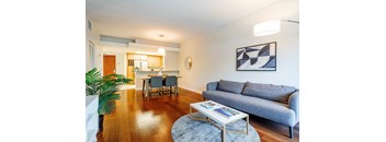 a living room with a couch coffee table and a kitchen in the background