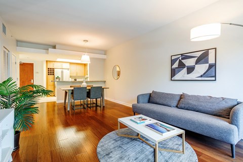 a living room with a couch coffee table and a kitchen in the background