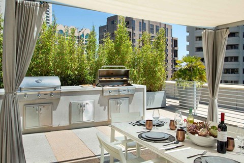 a kitchen with a grill and a table on a patio