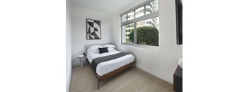 a bedroom with a bed and a window in a 555 waverly unit