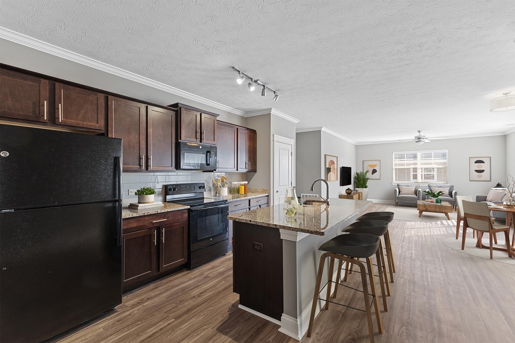 3 Bedroom Kitchen A modern kitchen with dark wood cabinets and a black refrigerator.