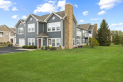 A large house with a grey exterior and a red door.