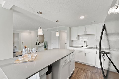 an open kitchen with white cabinets and a large counter top