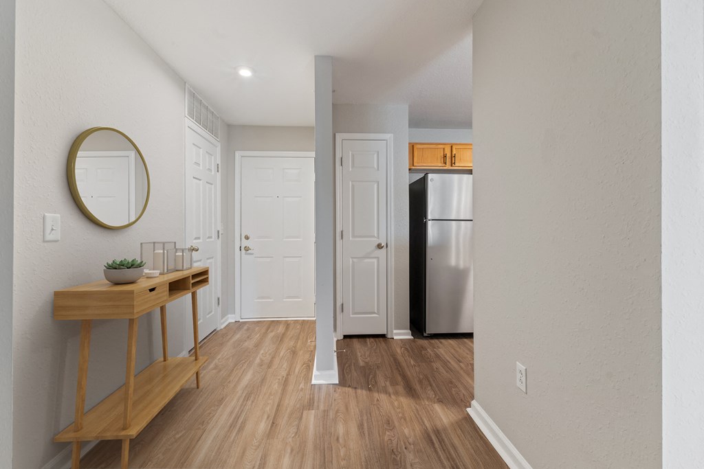 Enterance to an apartment with walk way into the kitchen and living room