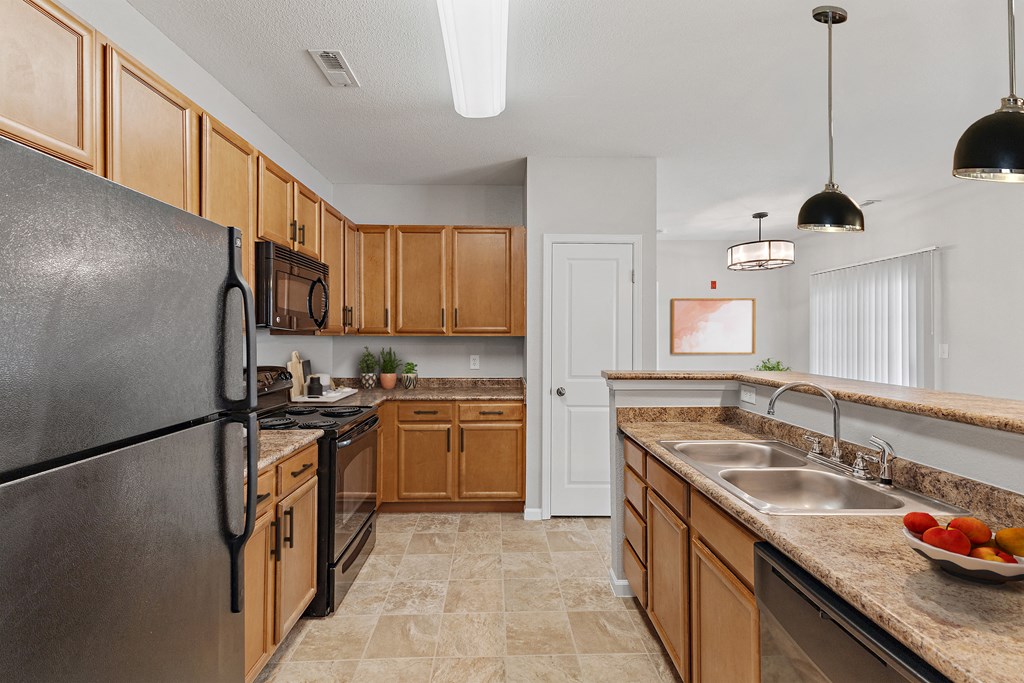 a kitchen with wood cabinets and black appliances