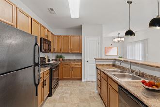Phase II Maple Cabinets Black Appliaances a kitchen with wood cabinets and black appliances - Photo Gallery