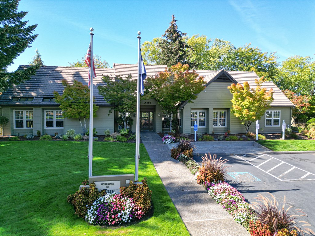 the front of a white house with two flags in front of it