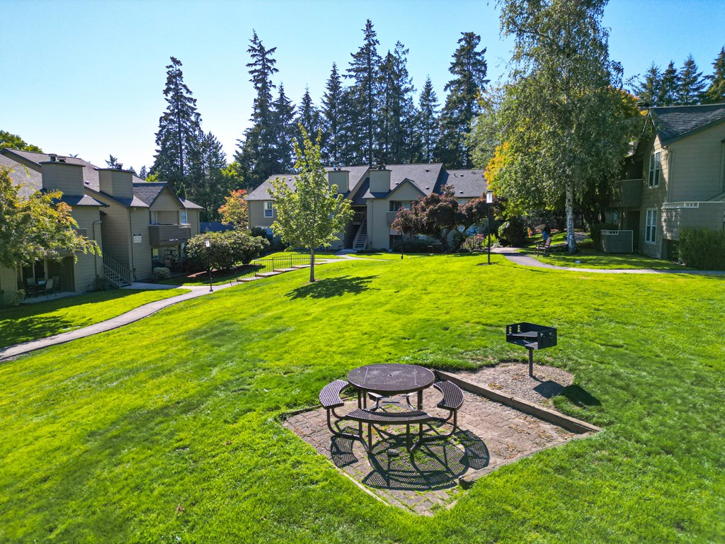 a backyard with a picnic table and a fire pit